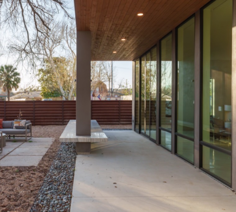 Covered patio with fallen leaves scattered across the concrete